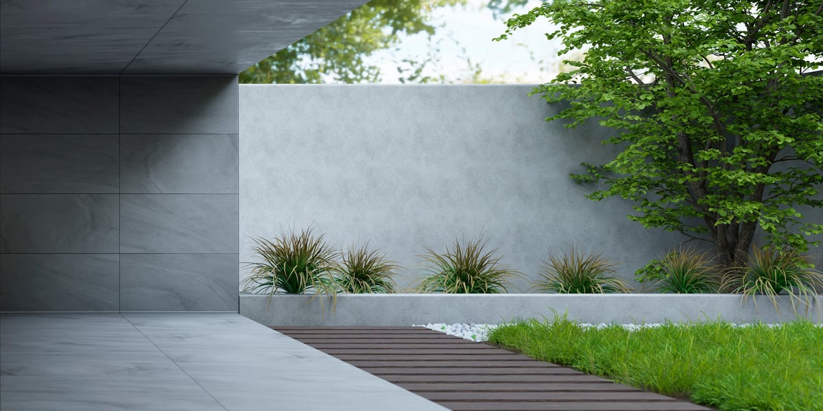 Clean concrete wall with natural light and greenery outside